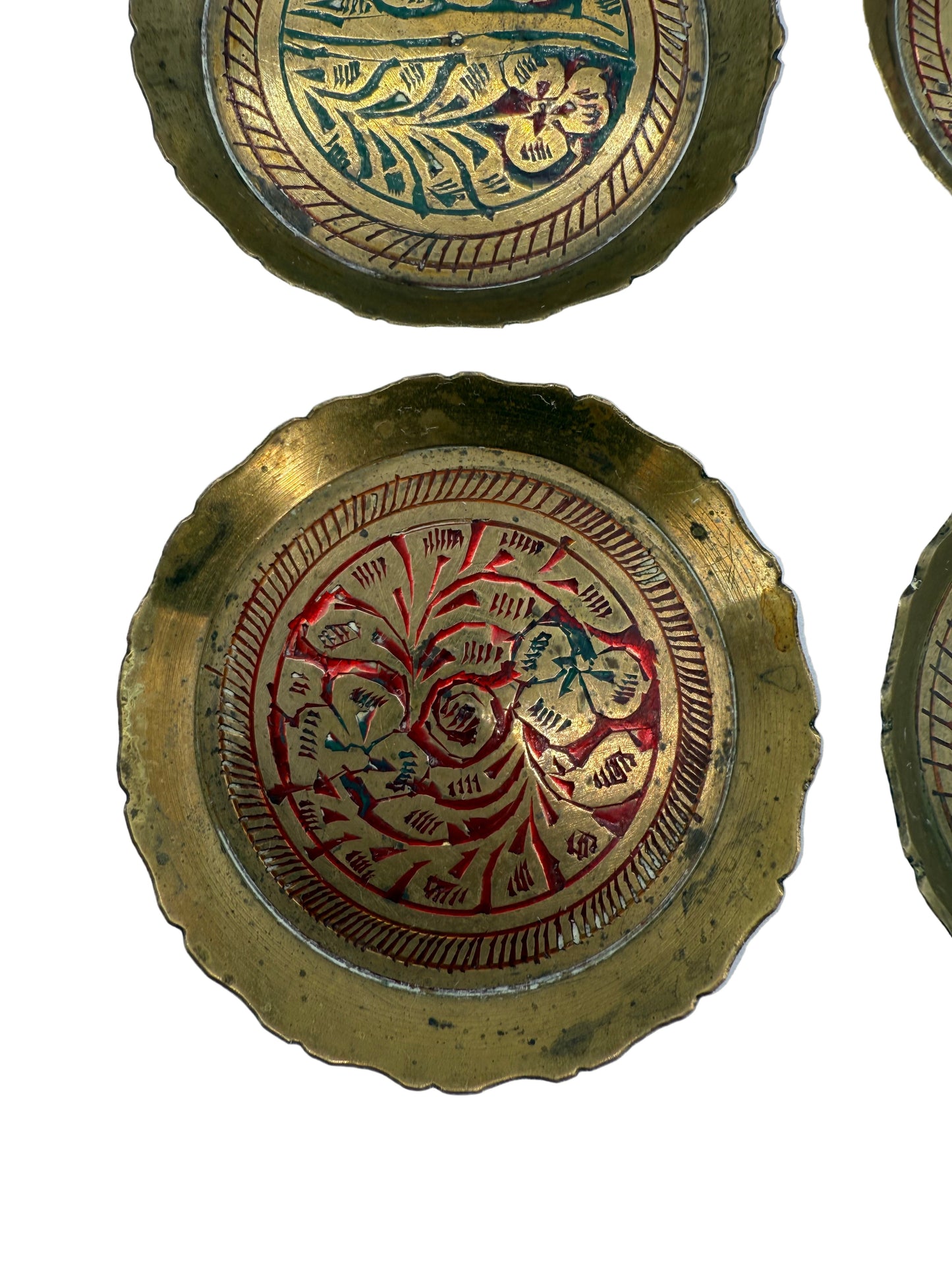 Decorative brass plates with intricate designs on a white background