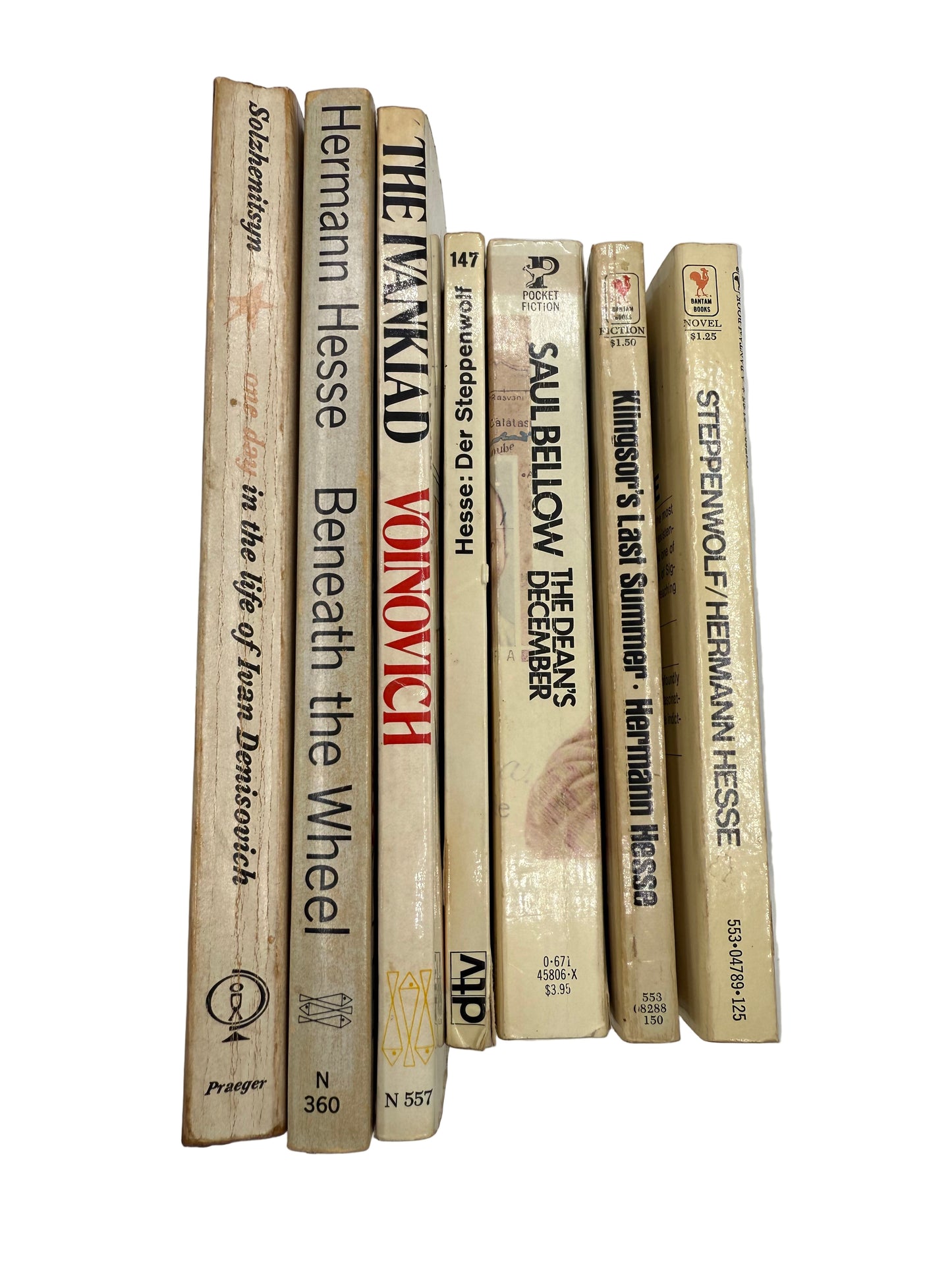 Stack of books held by a hand against a plain background