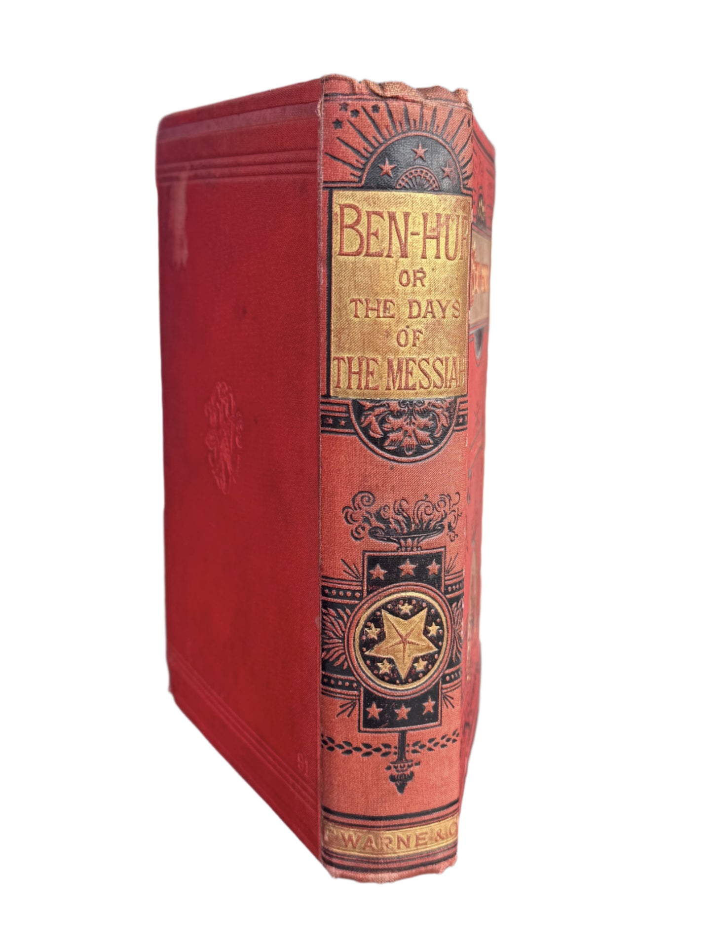 Red book with gold and black design on a wooden surface