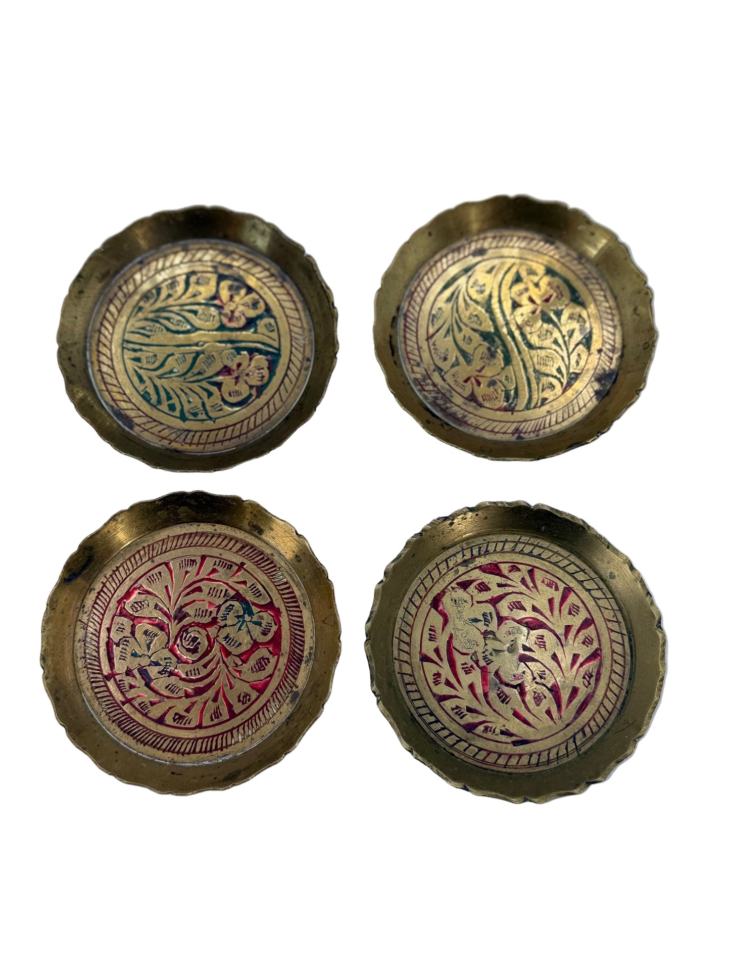 Four ornate brass buttons with intricate designs on a light blue background