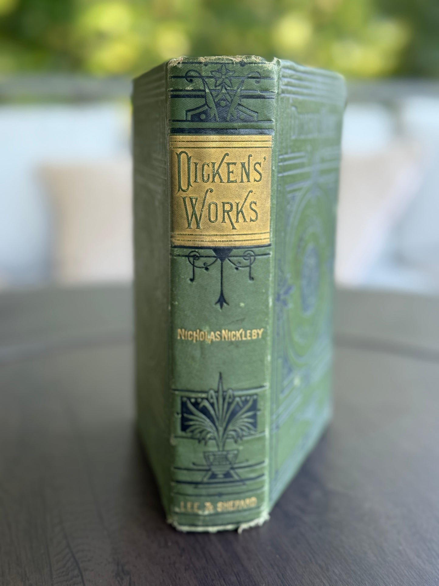 Vintage book titled 'Dickens' Works' with decorative green cover and gold lettering.
