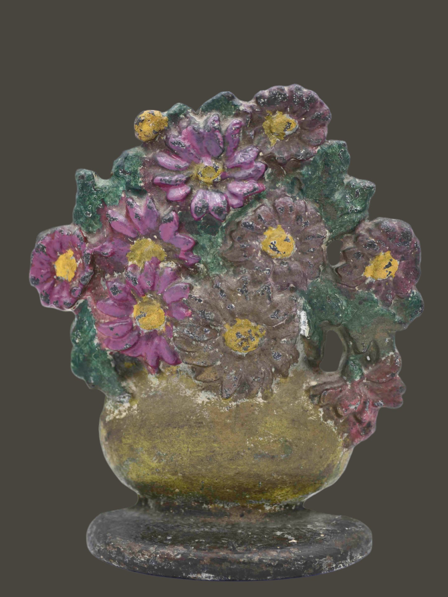 A vintage floral doorstop featuring pink and brown daisies in a gold vase with a white area in the center of the largest brown flower. The base is brown with light chipping, and the back is gold.