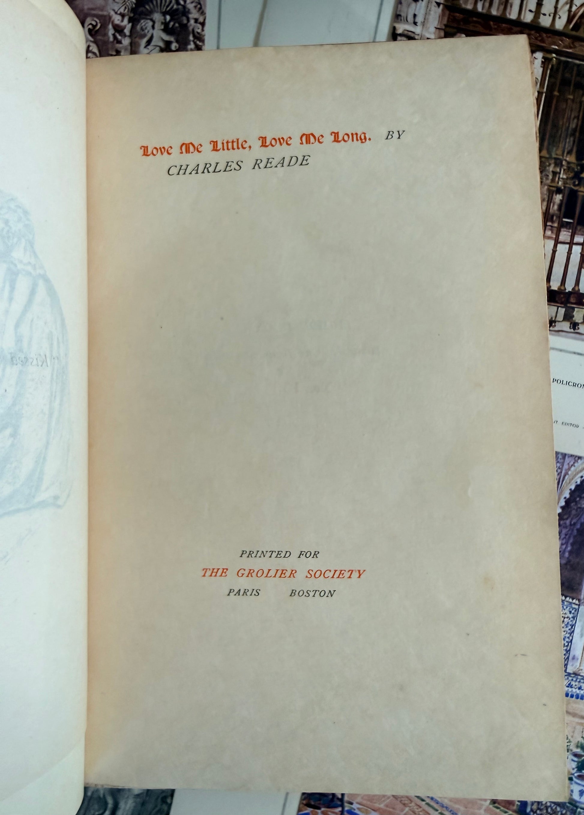 Title page of a book with text in red and black on beige paper, set against a patterned background.