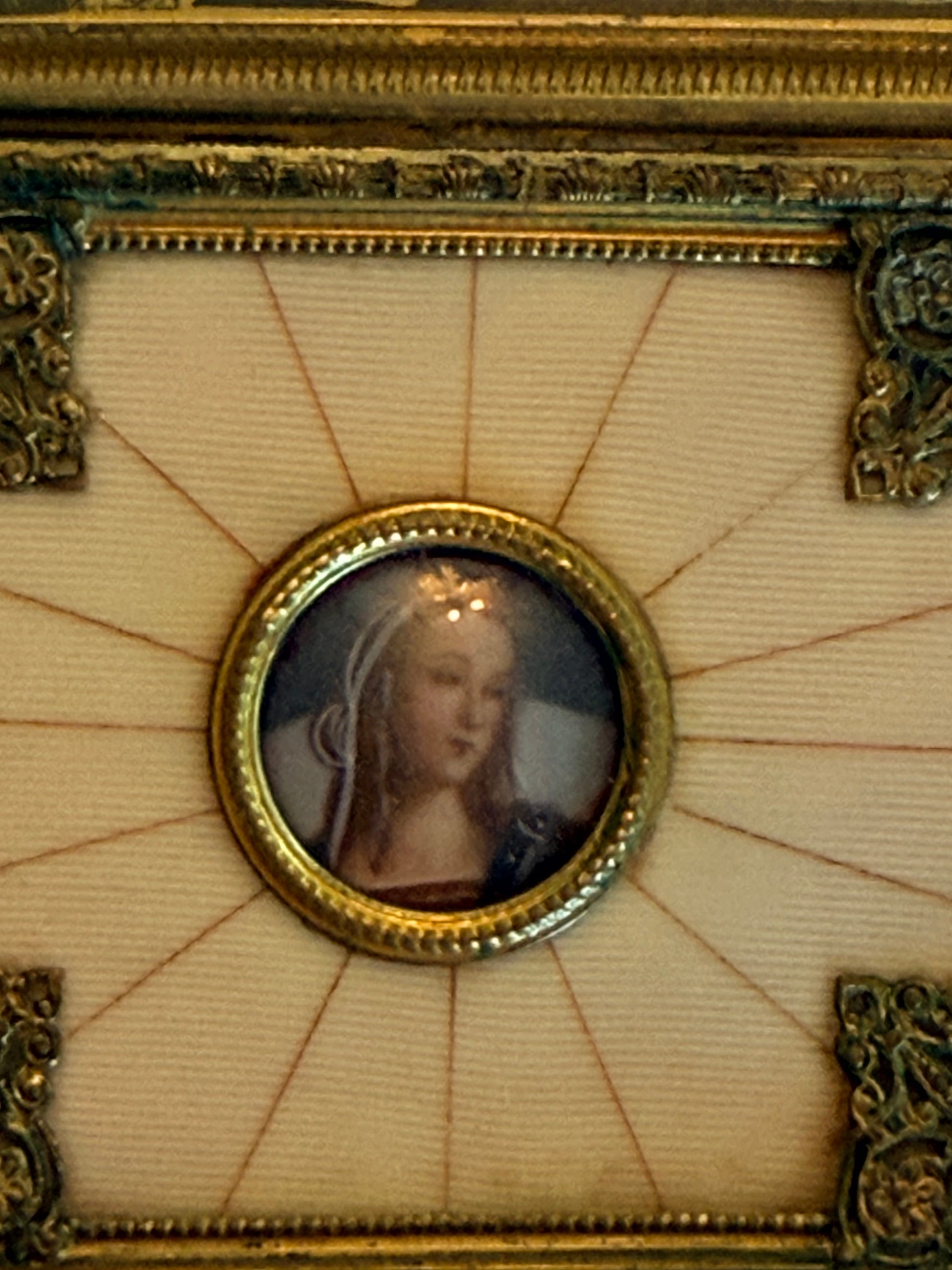 Decorative frame with a circular inset featuring a portrait on a beige background.