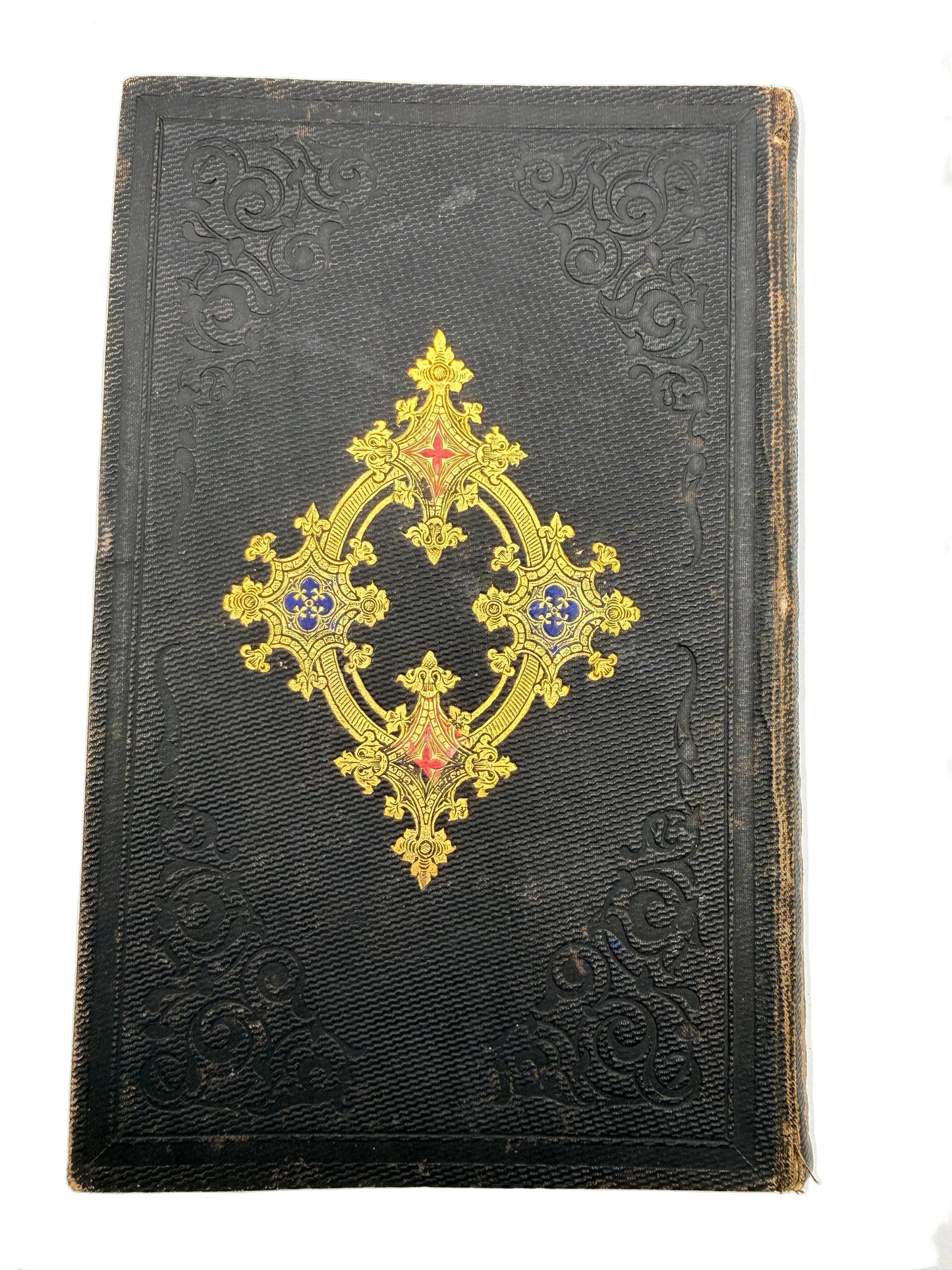Decorative black book with gold and red embellishments on a white background