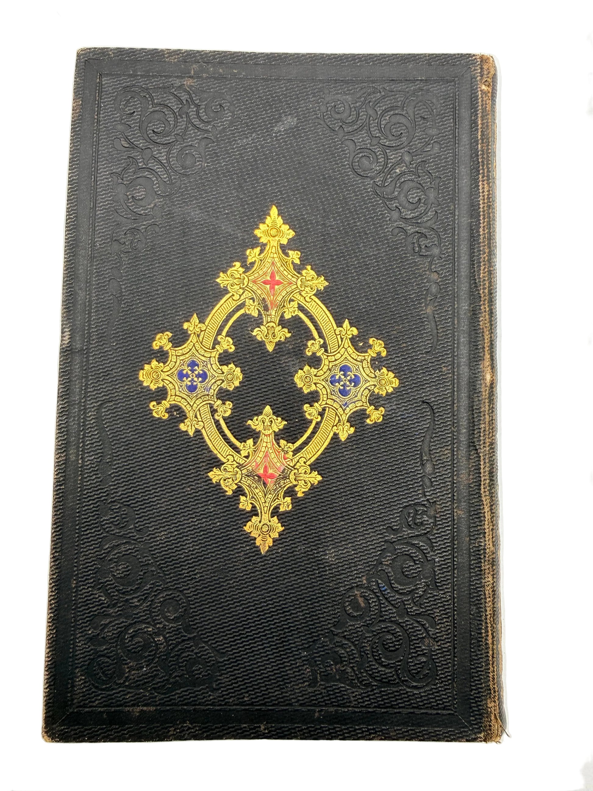 Decorative black book with gold and red embellishments on a white background