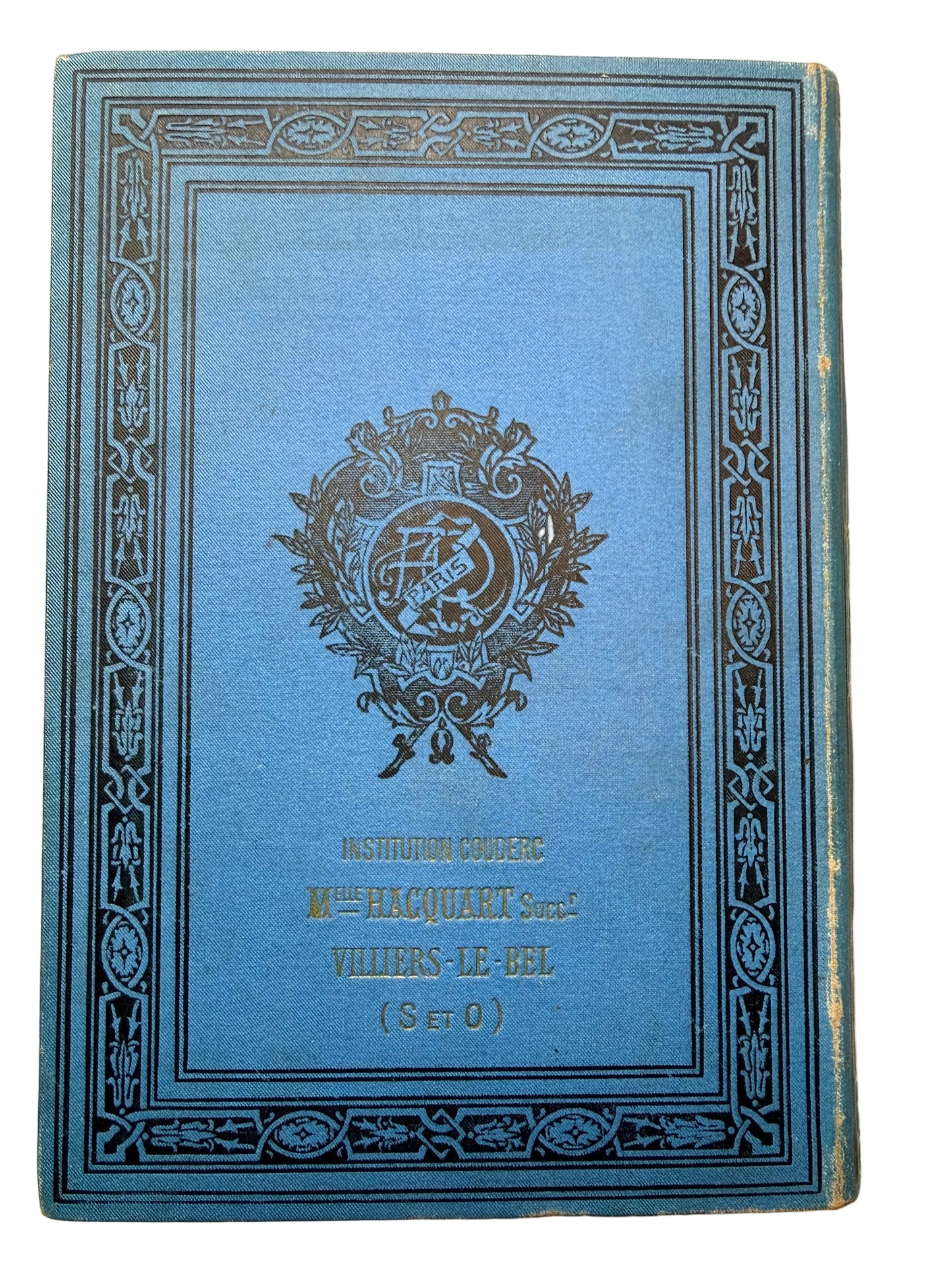 Blue book with decorative cover and emblem on a beige background