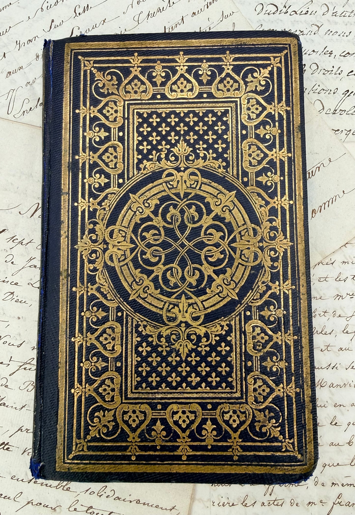 Decorative book cover with gold embossed design on a textured background