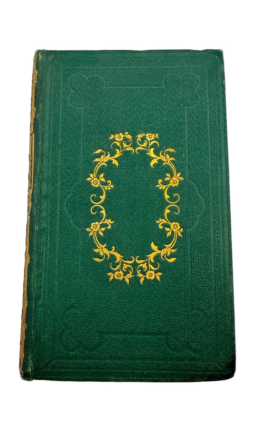 Green book with gold decorative emblem on a white background
