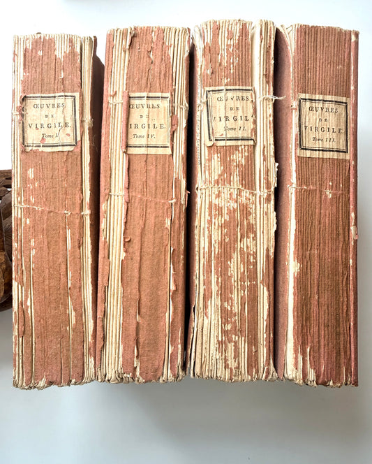 Set of four vintage books with brown spines and white text on a light gray background