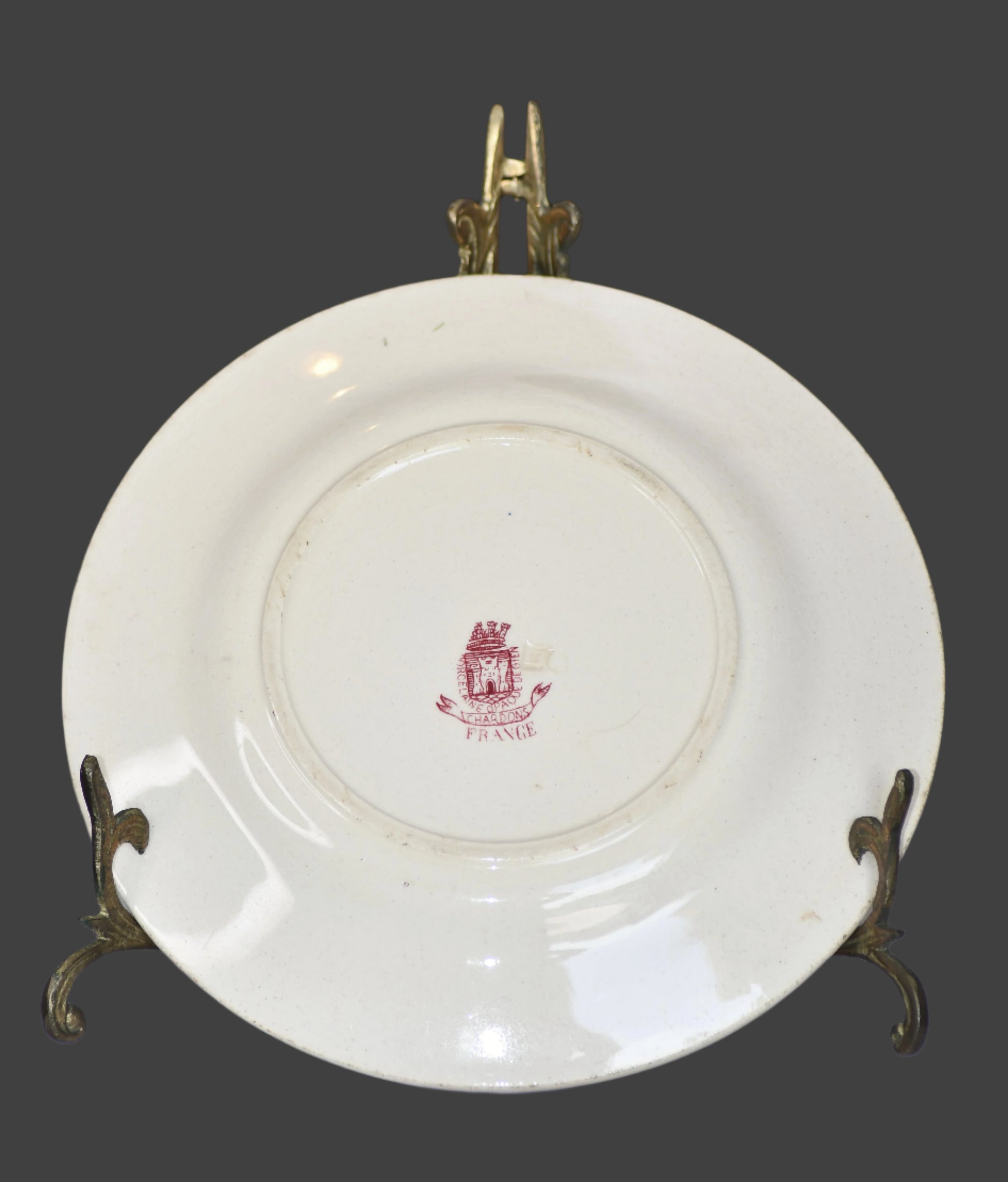 White plate with a red emblem on a stand, blurred background