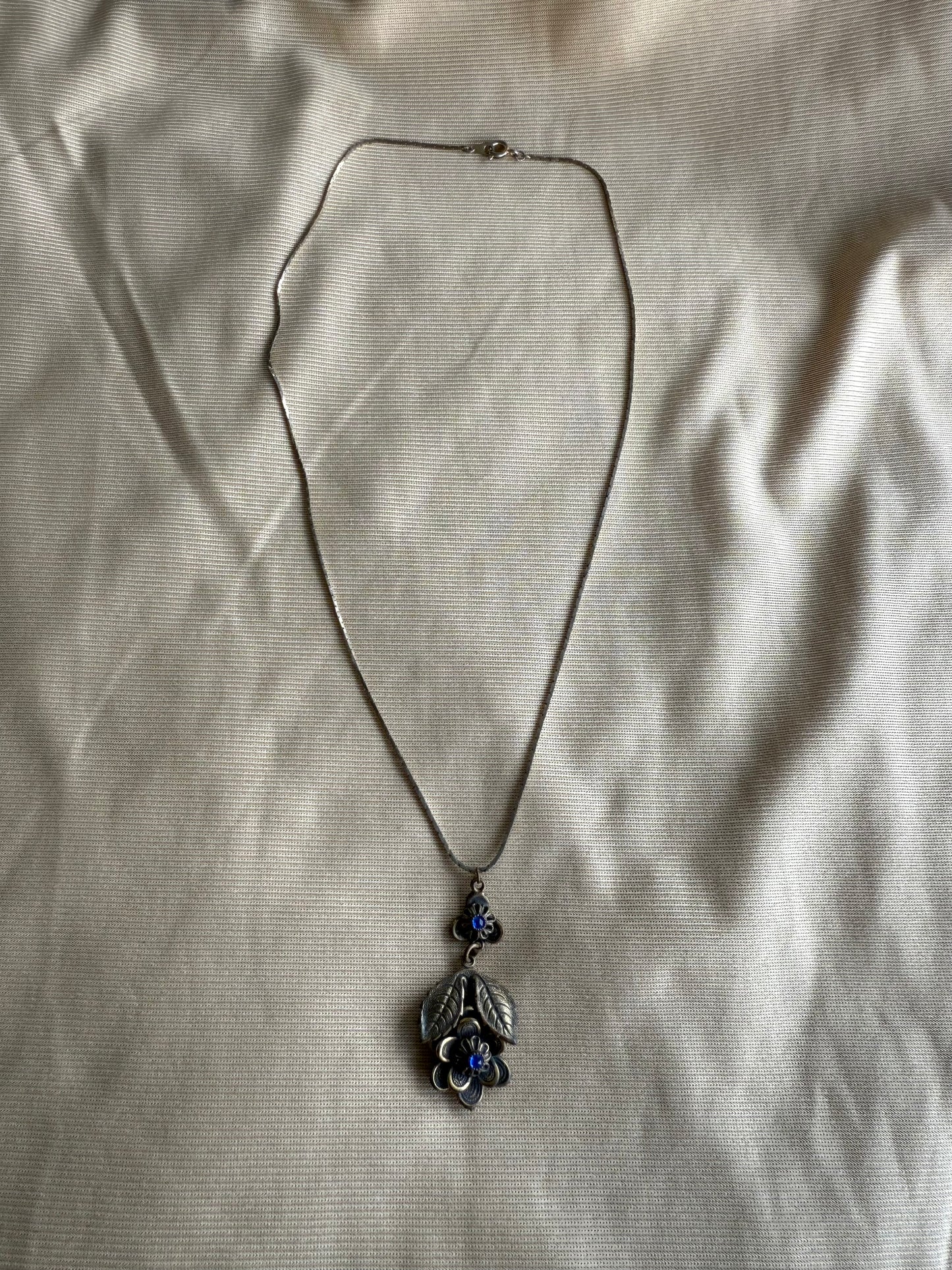 Necklace with a pendant on a beige fabric background