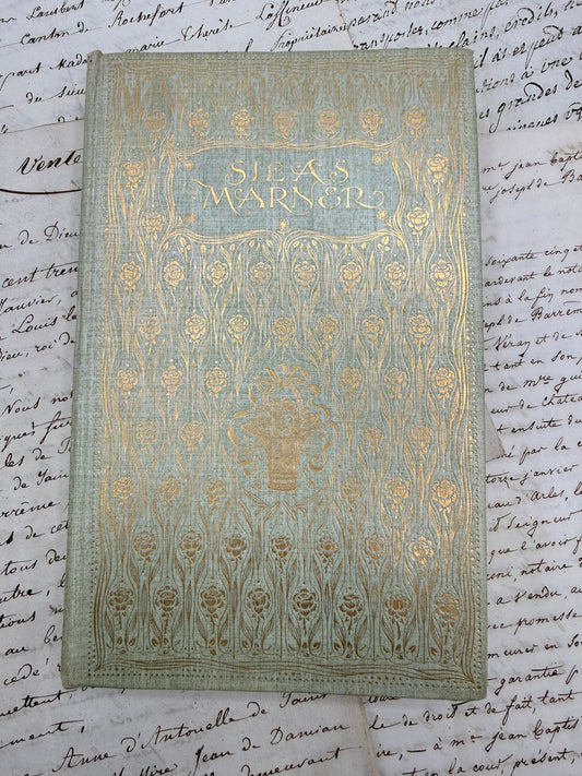 Decorative book cover with gold patterns on a handwritten paper background