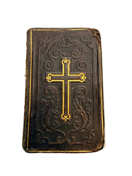 Decorative book with gold cross and intricate patterns on a white background