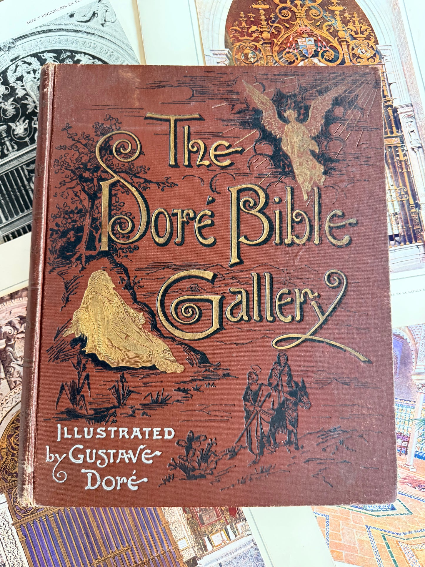 Vintage book titled 'The Dore Bible Gallery' with decorative cover on a patterned background