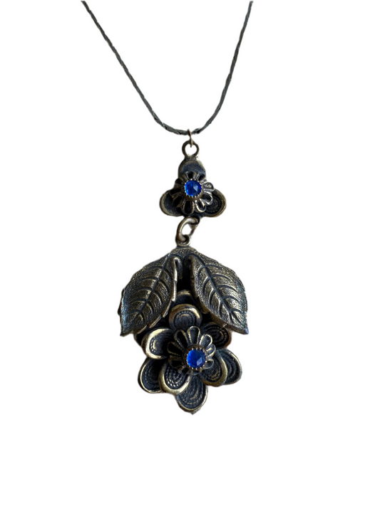 Floral pendant necklace with blue stones on a white background