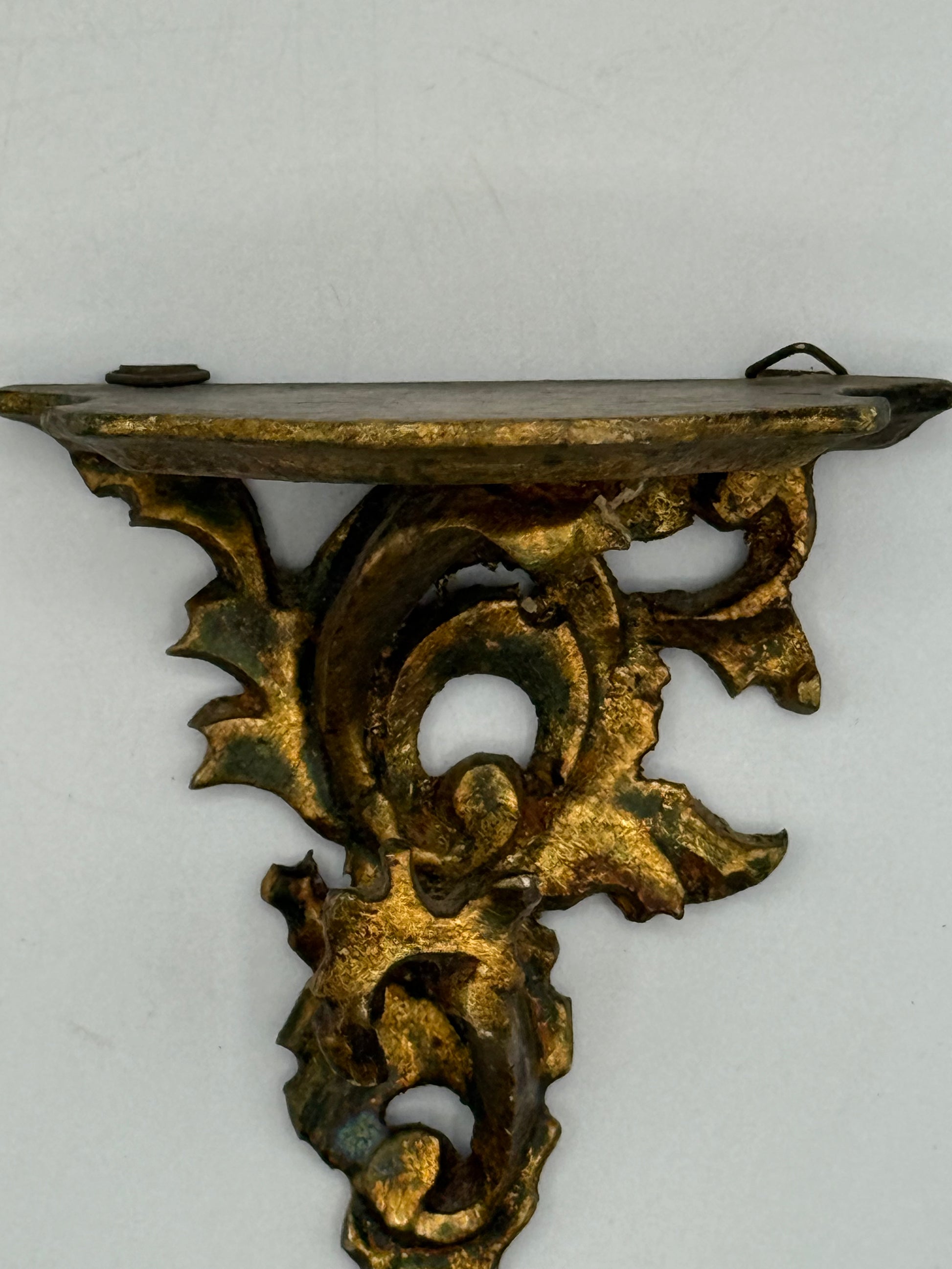 Decorative gold wood shelf bracket on a white background