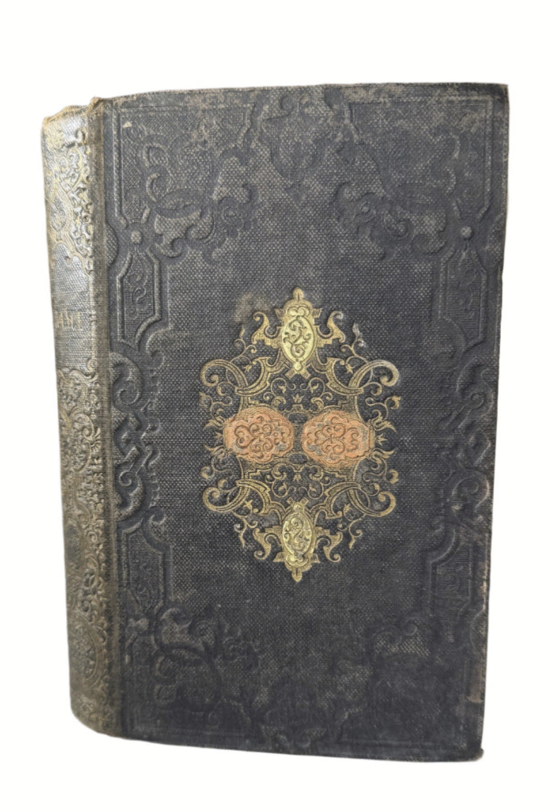 Decorative old book with gold embossed design on a gray surface