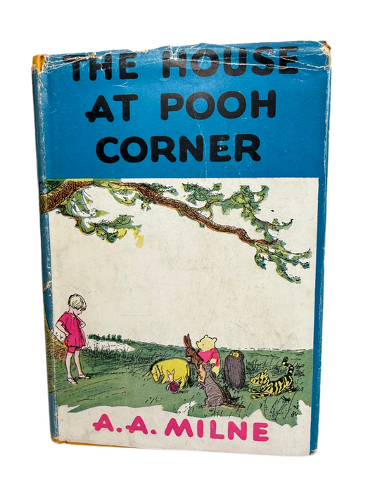 Book cover of 'The House at Pooh Corner' by A.A. Milne with a blue background and illustrations of characters.
