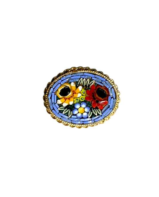 Decorative brooch with floral design on a textured fabric background