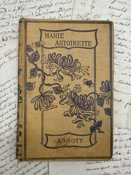 Vintage book titled 'Marie Antoinette' by Abbott on a textured background with handwritten text.