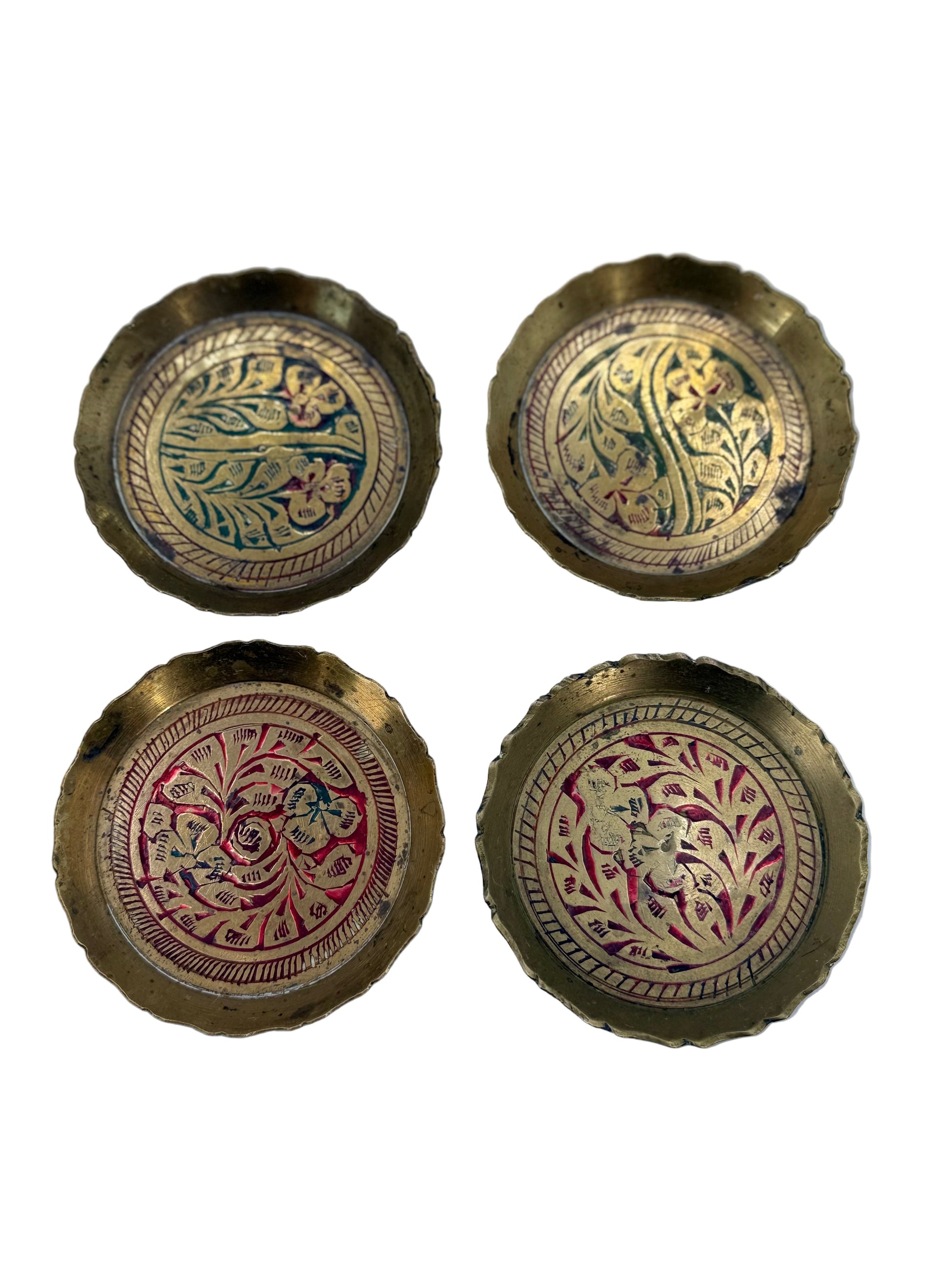 Four ornate brass buttons with intricate designs on a light blue background