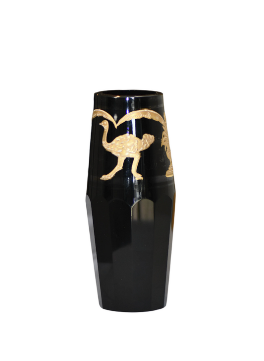 Black vase with gold bird design on a gray background
