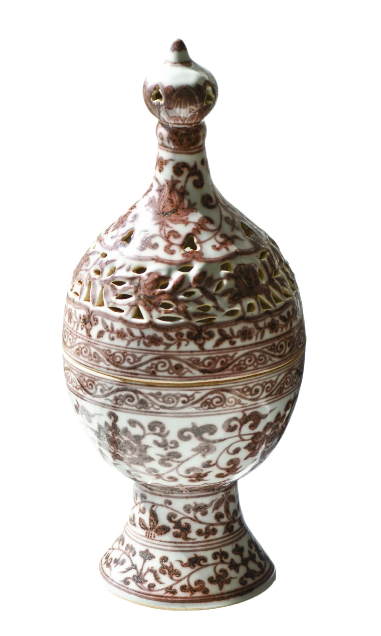 A white ceramic incense burner with red underglaze patterns, including floral designs and geometric scrollwork, displayed against a light-filled background.