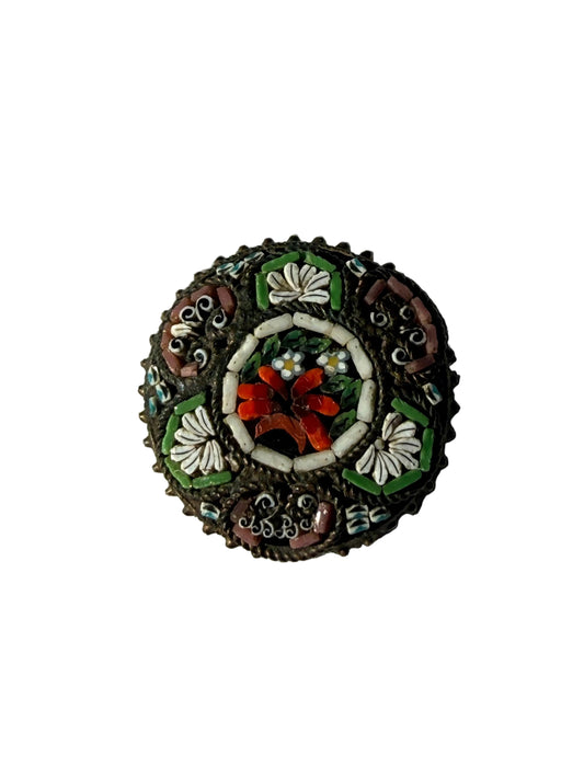 Decorative brooch with floral design on a textured fabric background