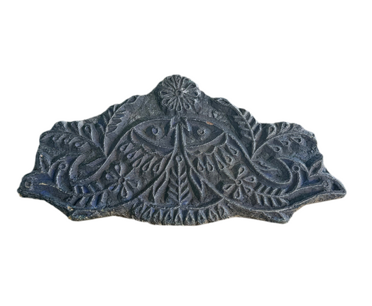 Decorative stone tile with intricate patterns on a white background