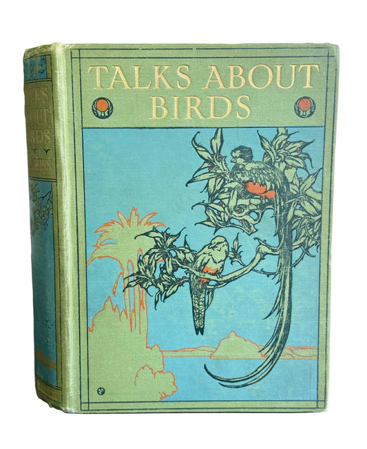Book titled 'Talks About Birds' with bird illustrations on a wooden surface